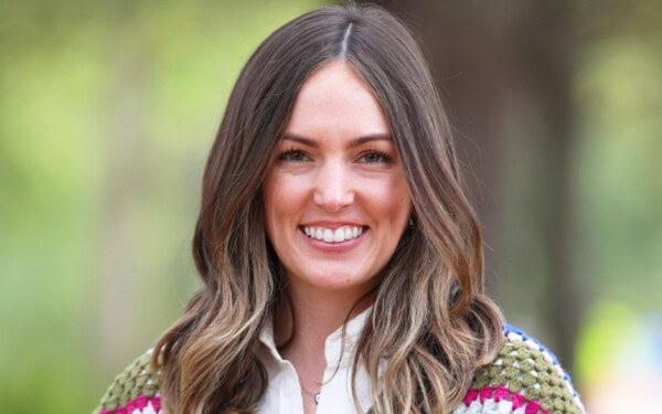 A woman with long brown hair and a white shirt smiles outdoors, reflecting the warmth of Baton Rouge Presbyterian Church services.