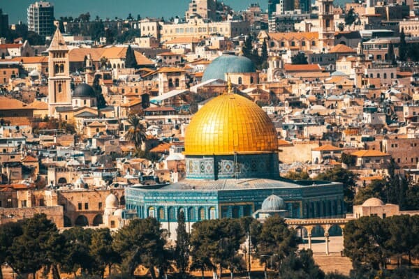 A view of Jerusalem on an Israel tour, featuring the Dome of the Rock with its gold dome, surrounded by historic buildings and trees.
